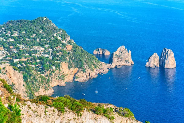 Barcos cerca de acantilados de Faraglioni con el mar Tirreno de la isla de Capri — Foto de Stock