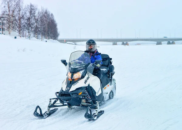 Hombre montando moto de nieve en el lago congelado en invierno Rovaniemi — Foto de Stock