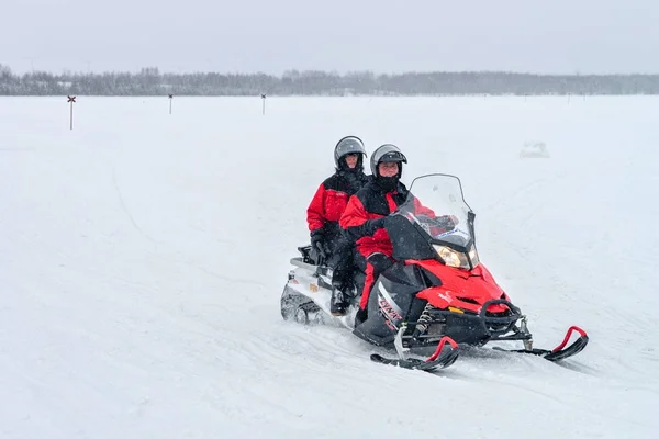 Pessoas montando snowmobile em lago congelado no inverno Rovaniemi — Fotografia de Stock