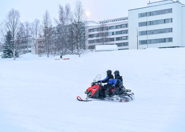 As pessoas montam snowmobile no lago de neve congelado no inverno Rovaniemi — Fotografia de Stock