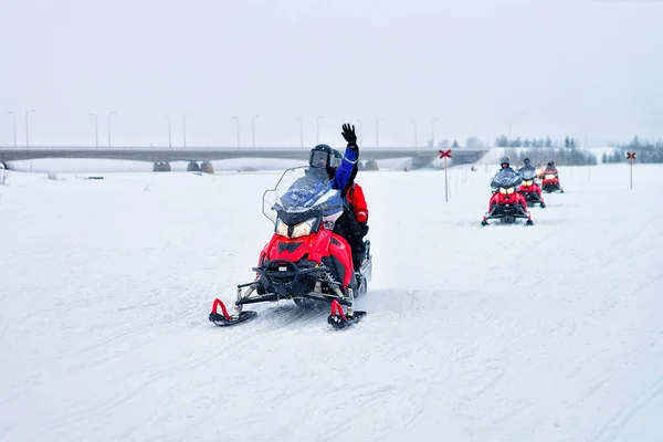 Pessoas montando motos de neve e acenando as mãos em Rovaniemi — Fotografia de Stock