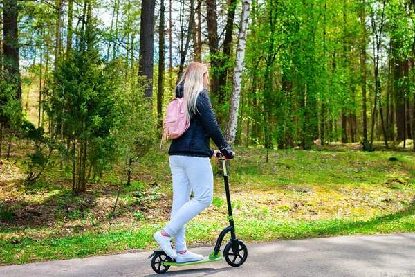 Druskininkai parkında itme scooter üzerinde genç kadın