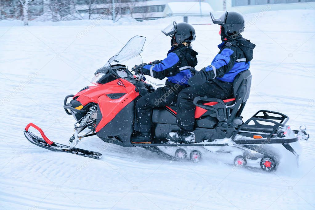 People ride snowmobile in frozen snow lake in winter Rovaniemi