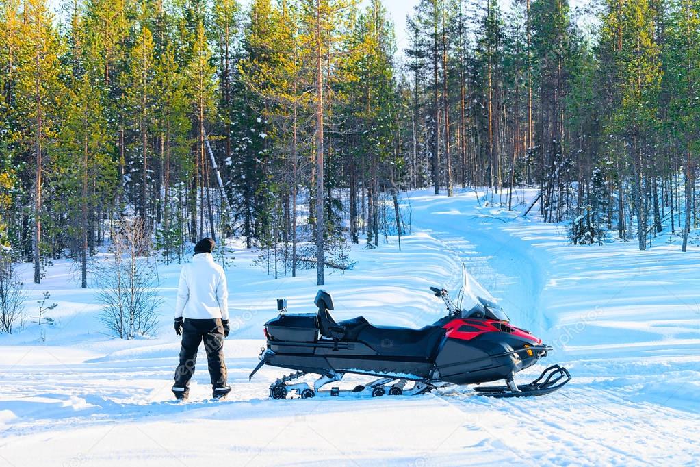 Woman at snowmobile on frozen lake at winter Rovaniemi