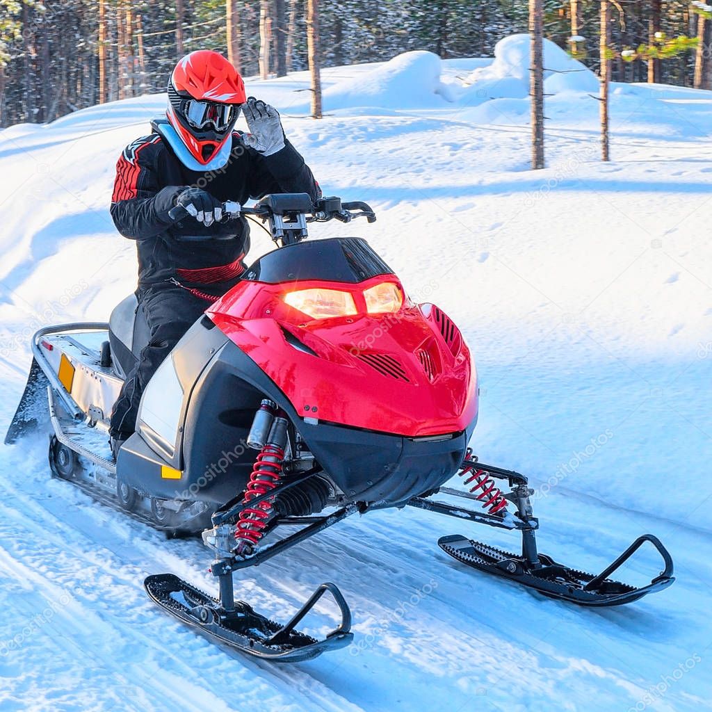 Woman riding red snowmobile on frozen lake winter Rovaniemi