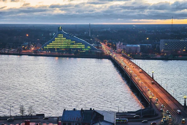 Akmens bron över floden Daugava i Riga och nationella bibliotek — Stockfoto
