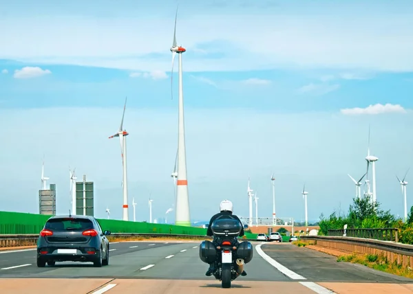 Wind mills and motorbike on road in Switzerland