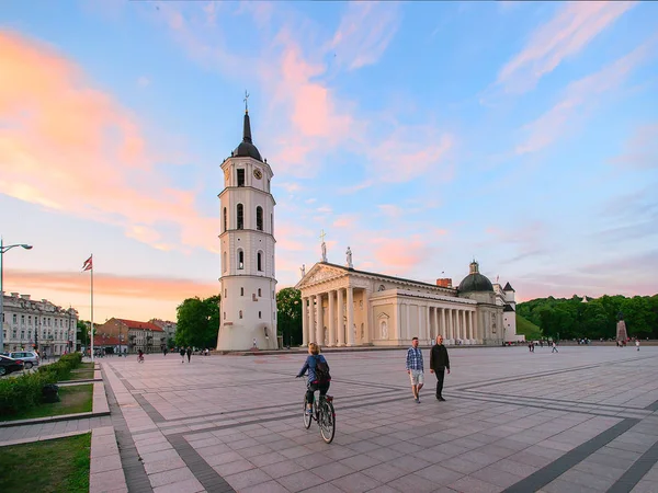 Lidé na náměstí a Bell tower Vilnius při západu slunce — Stock fotografie