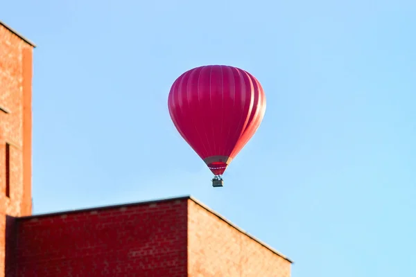 Globo de aire rojo volando sobre edificio residencial de la casa — Foto de Stock