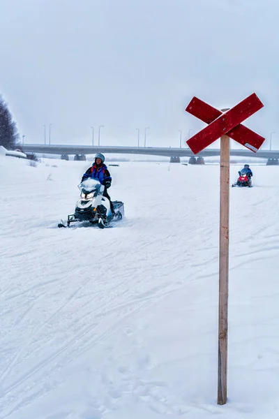 Homens montando snowmobile no lago congelado no inverno Rovaniemi — Fotografia de Stock