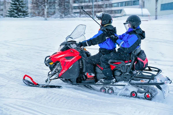 Hombre montando moto de nieve y mujer con palo selfie Finlandia Rovaniemi —  Fotos de Stock