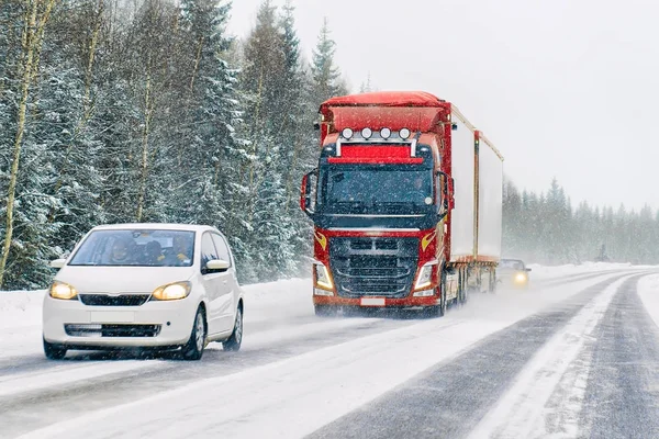 Автомобиль и грузовик в дороге зимой — стоковое фото