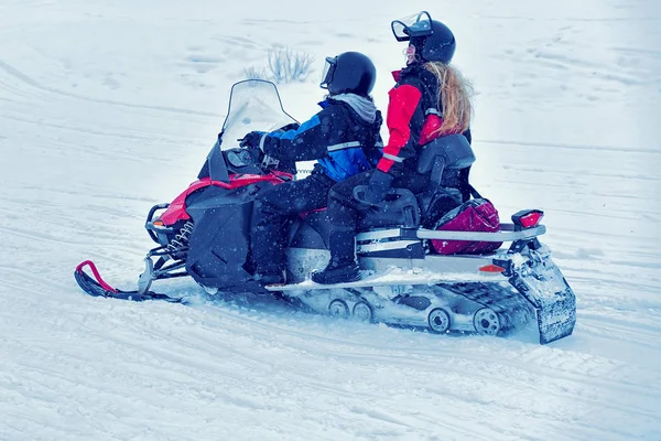 Kinderen, sneeuwscooter rijden op bevroren meer op winter Rovaniemi — Stockfoto