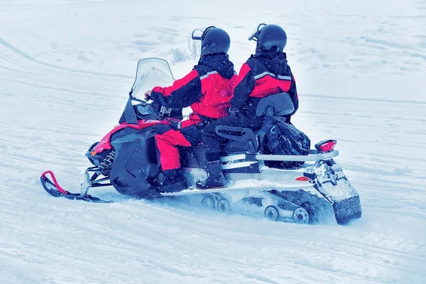 Casal equitação snowmobile no lago congelado no inverno Rovaniemi — Fotografia de Stock