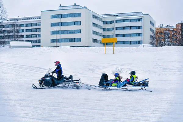 Homem montando snowmobile e crianças em carruagem Rovaniemi — Fotografia de Stock