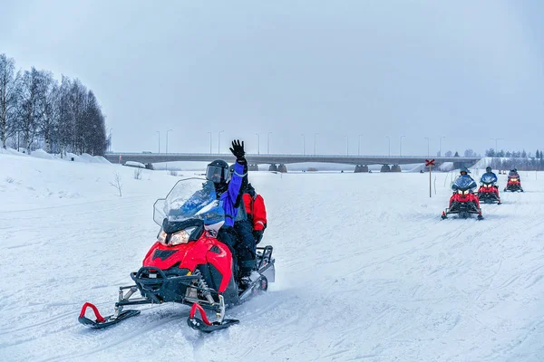 얼어붙은 호수 겨울 로바니에미에 손을 흔들며 snowmobile에 사람들 — 스톡 사진