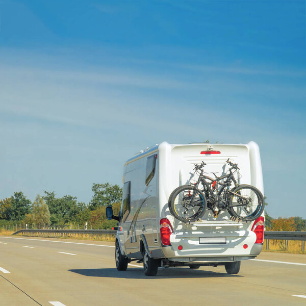 Caravan with bicycle on road in Switzerland