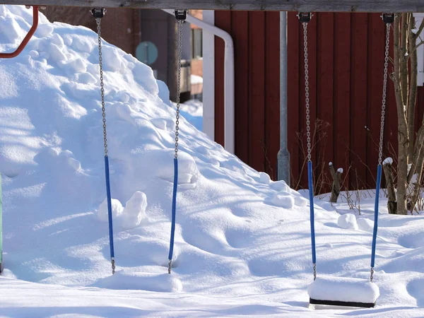 被雪覆盖的秋千作为户外设施罗瓦涅米 — 图库照片