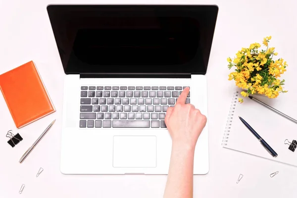 Espacio de trabajo y la mano de la mujer que trabaja en el teclado portátil flores amarillas — Foto de Stock