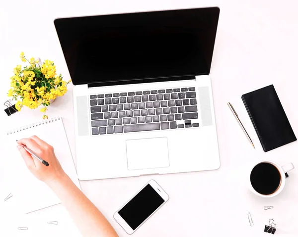Espacio de trabajo con la mano de la mujer sosteniendo el lápiz portátil flores de café móviles — Foto de Stock