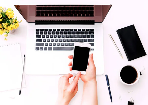 Espacio de trabajo con la mano de la mujer teléfono portátil teclado flores amarillas — Foto de Stock