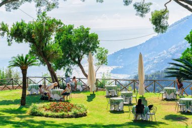 İnsanlar şemsiye Ravello köyü ile açık hava sokak restoranda