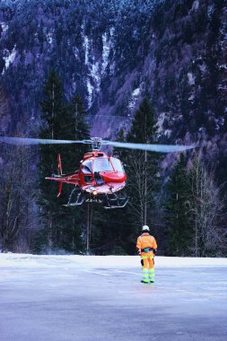 Kırmızı helikopter ve Swiss Alpine heliport pilot