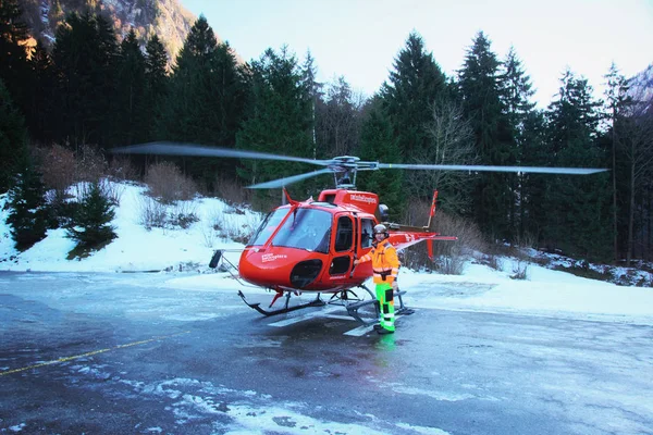 Pilota ed elicottero rosso all'eliporto alpino svizzero inverno Gsteigwiler — Foto Stock