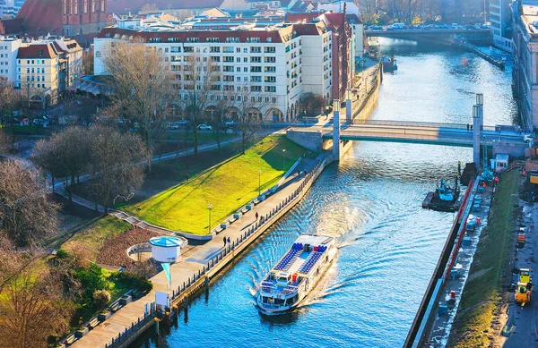 Cityscape and excursion ship on Spree river in Berlin