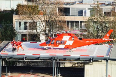 Helicopter and patient at hospital roof in Thun City clipart