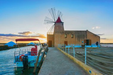 Gün batımı yel değirmeni ve tuz evoporation su birikintisi Marsala Sicilya