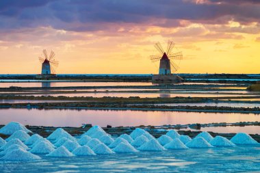 Tuz evoporation gölet Marsala Sicilya'daki yel değirmenleri gün batımında