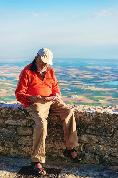 Старший человек, читающий туристическую карту в Эриче Сицилия — стоковое фото