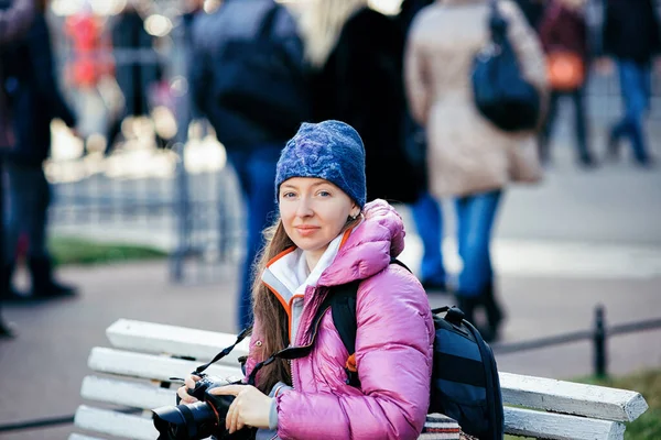 Young lady with camera sitting on the bench in St Petersburg — Stock Photo, Image