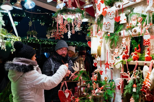 Muž nákup keramiky vánoční stromky dekorace Noční trh Gendarmenmarkt Berlin — Stock fotografie