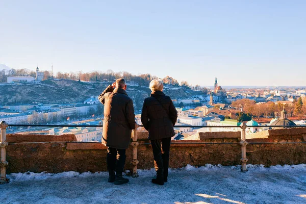 Pareja mayor mirando Panorama de Salzburgo con nieve —  Fotos de Stock