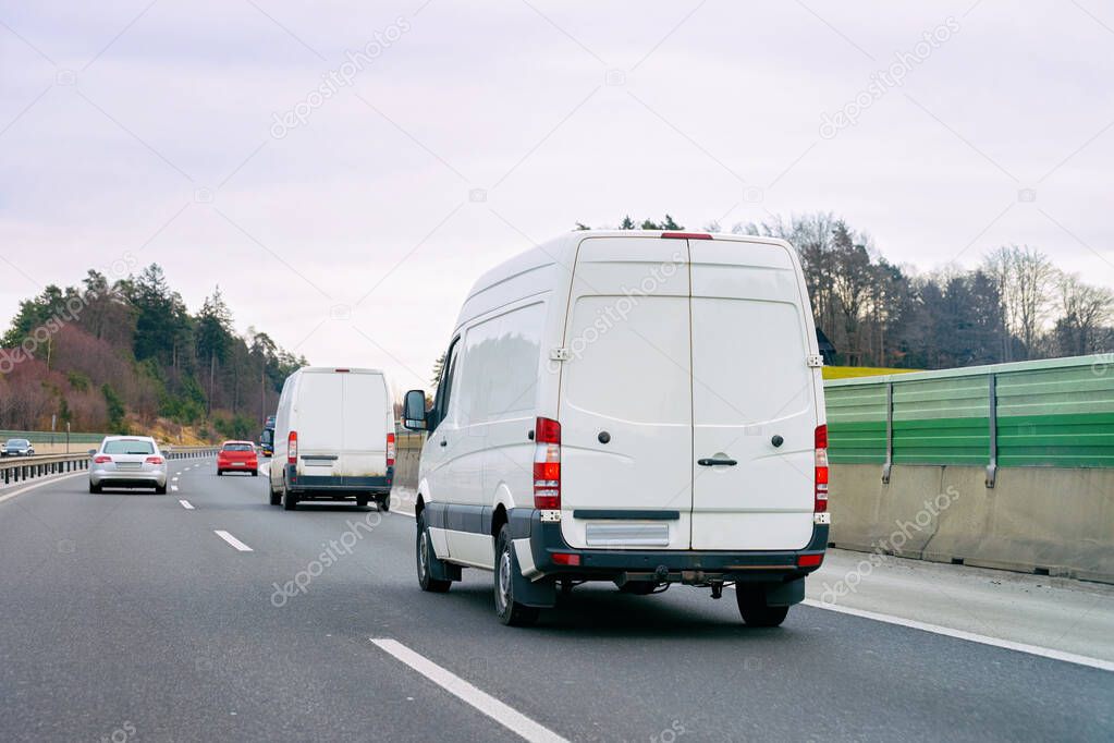 White Minivans in road European van transport