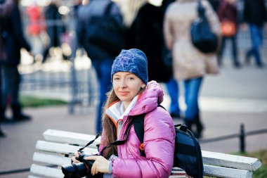 St. Petersburg 'da bankta oturan kameralı genç bayan.
