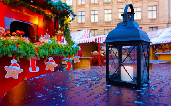 Linterna con una vela encendida sobre una mesa en una feria de Navidad en Riga reflex — Foto de Stock