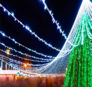 Noel pazarındaki insanlar ve Xmas ağacı Vilnius gece refleksi