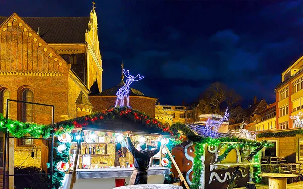 Christmas stalls decorated with glowing deer statues in old Riga reflex — Stock Photo, Image