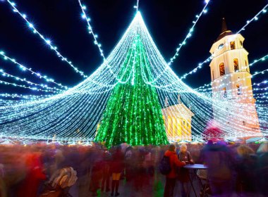 Vilnius Noel pazarındaki insanlar ve Xmas ağacı akşam refleksi
