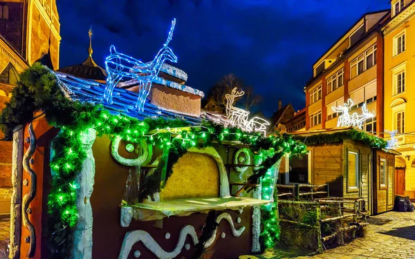 古いリガ反射で明るい鹿のフィギュアで飾られたクリスマスの屋台 — ストック写真