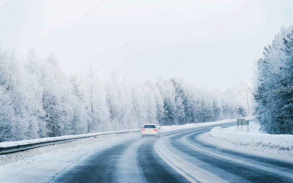 Car in a road at a snowy winter Lapland reflex