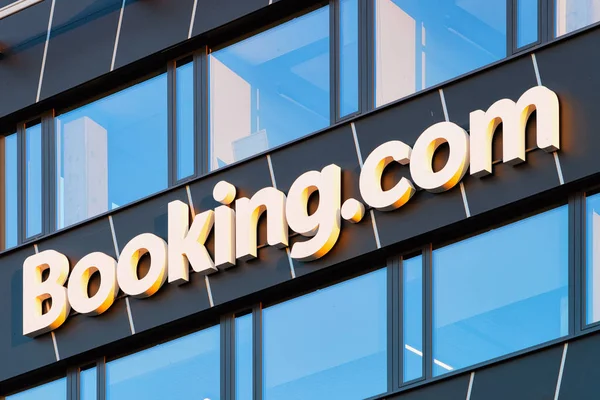 Bokning com logotyp och moderna kontorshotell — Stockfoto