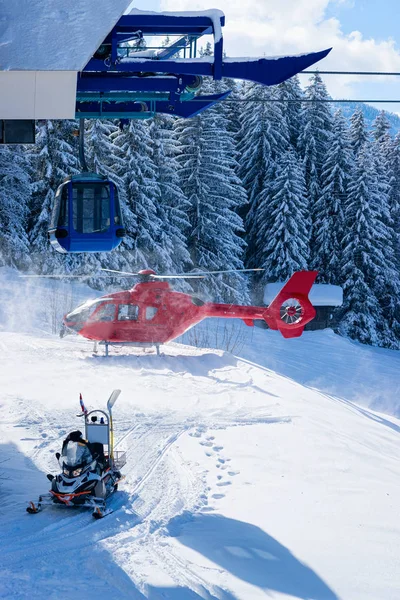 Motorschlitten und roter Helikopter parkten Seilbahnstation Zillertal Arena — Stockfoto