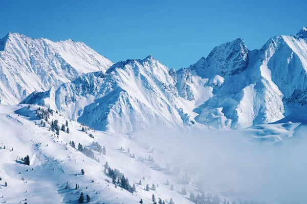 Paesaggio nella località sciistica Zillertal Arena tra le nuvole dell'Austria Foto Stock Royalty Free