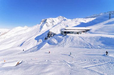 Kayakçılar ve snowboardcular Hintertux Buzulu 'ndaki Cable araba istasyonu.