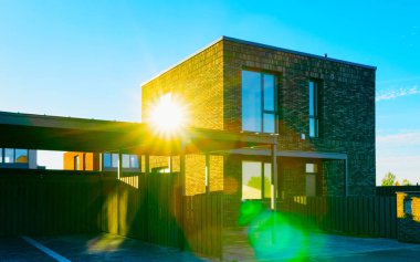 Park yeri güneş ışığı refleksli apartman mimarisi.