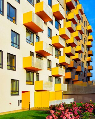 Çit refleksi ve çiçeklerle harici modern apartman binası.